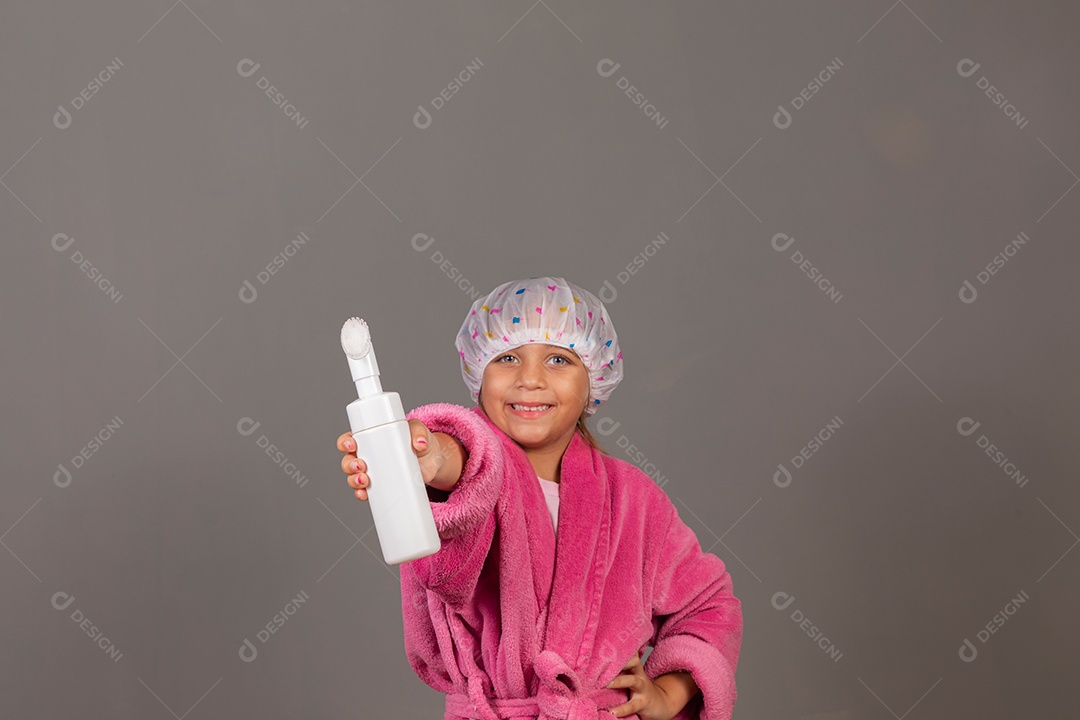 Linda menina usando roupão de banho rosa touca esfoliante sobre fundo isolado