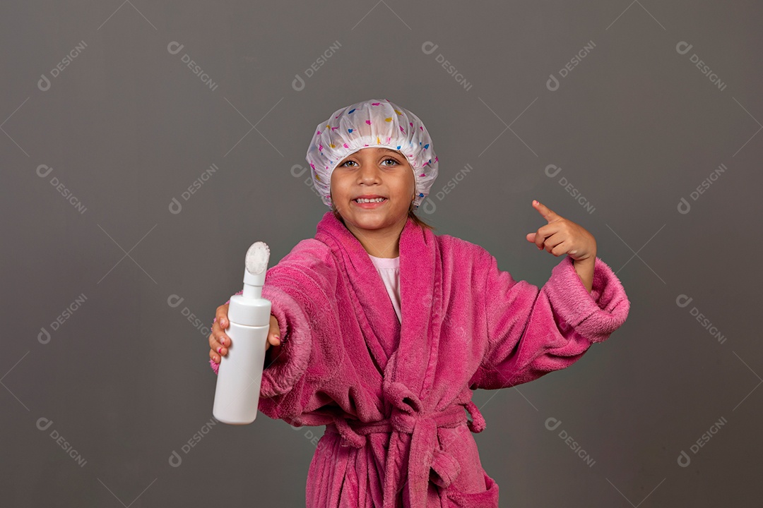 Linda menina usando roupão de banho rosa touca esfoliante sobre fundo isolado