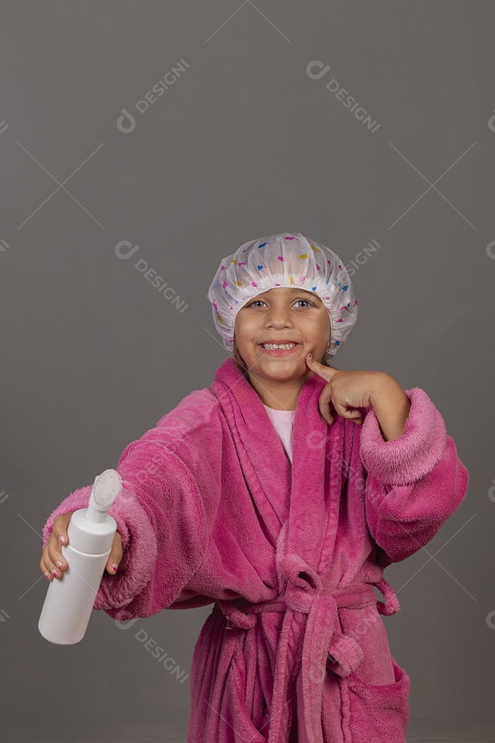 Linda menina usando roupão de banho rosa touca esfoliante sobre fundo isolado