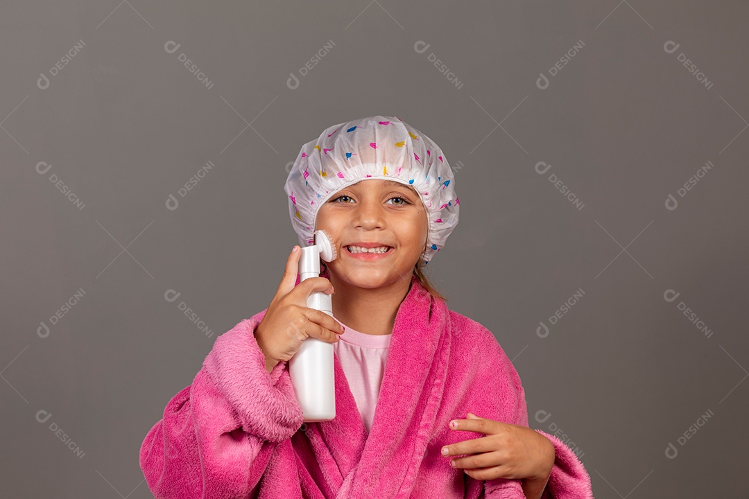 Linda menina usando roupão de banho rosa touca esfoliante sobre fundo isolado