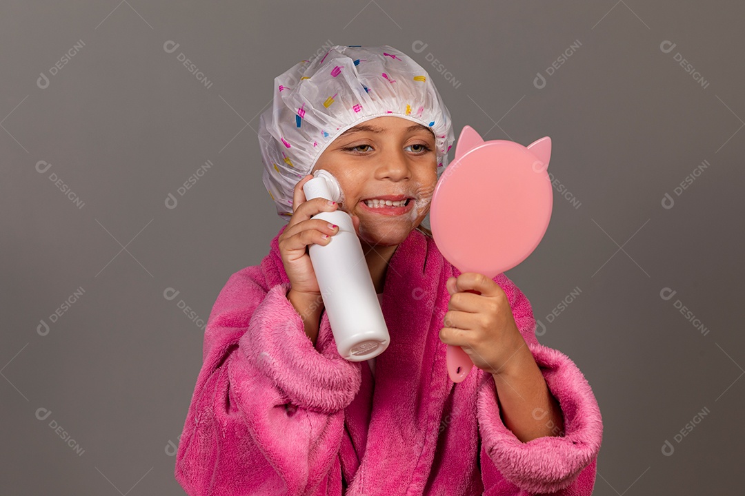 Linda menina usando roupão de banho rosa touca esfoliante espelho sobre fundo isolado