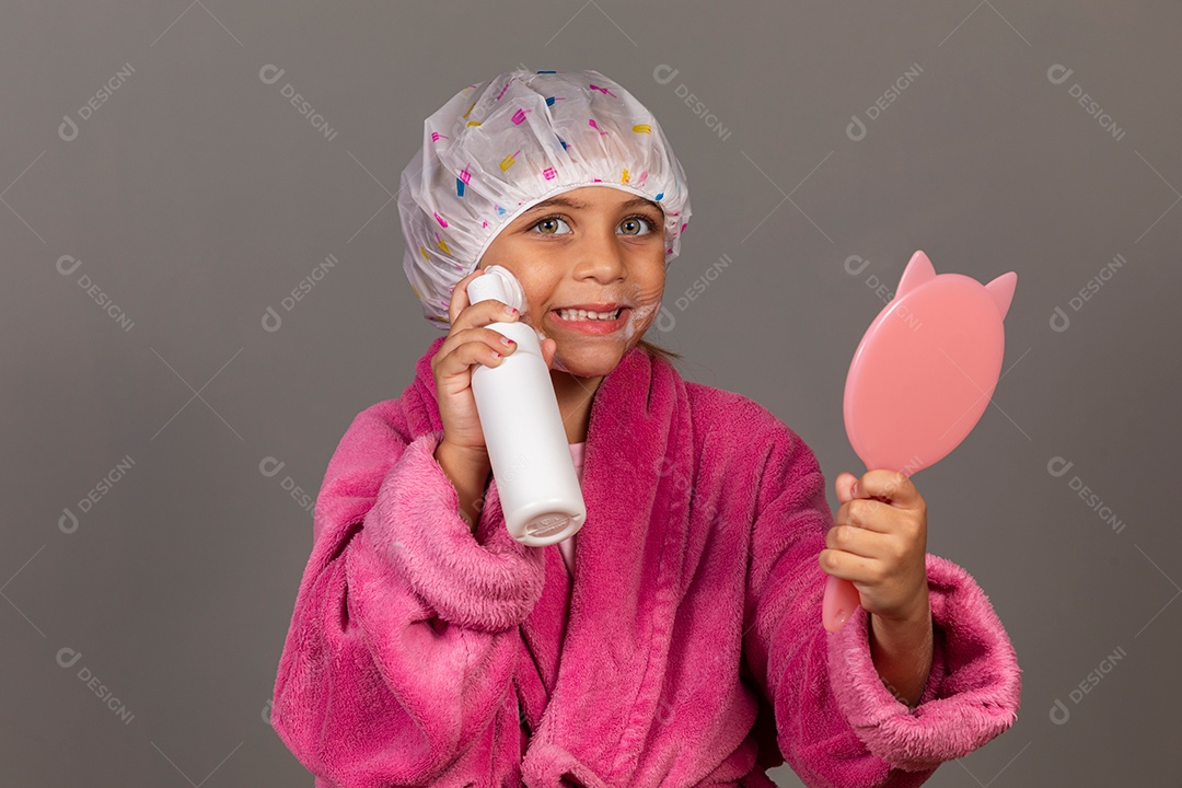 Linda menina usando roupão de banho rosa touca esfoliante espelho sobre fundo isolado