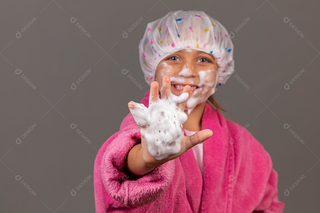Linda menina usando roupão de banho rosa touca esfoliante sobre fundo isolado