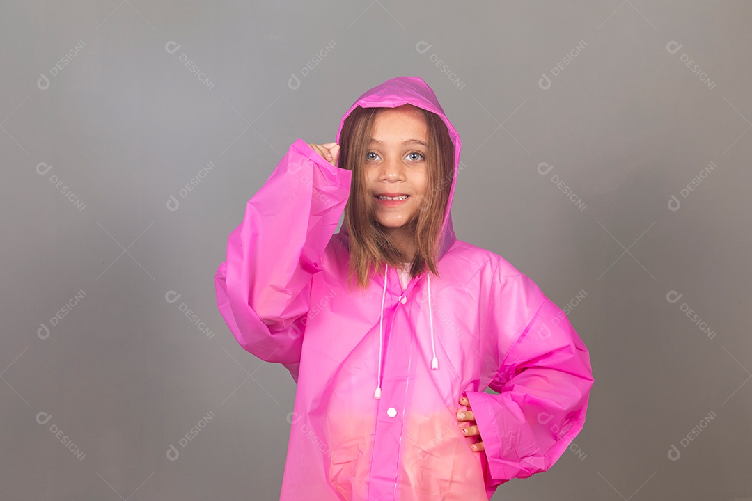 Linda menina usando capa de chuva rosa sobre fundo isolado