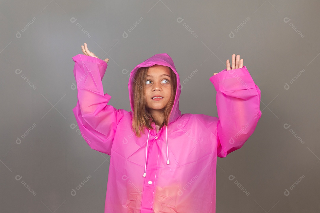 Garota linda usando capa de chuva rosa sobre fundo isolado