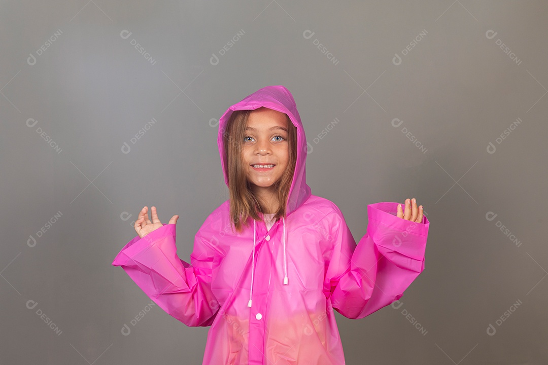 Garota linda usando capa de chuva rosa sobre fundo isolado