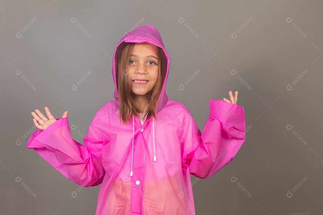 Garota linda usando capa de chuva rosa sobre fundo isolado