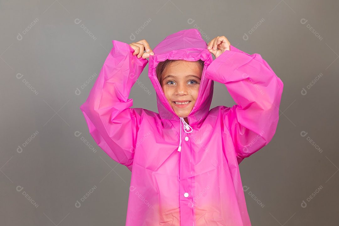 Garota linda usando capa de chuva rosa sobre fundo isolado