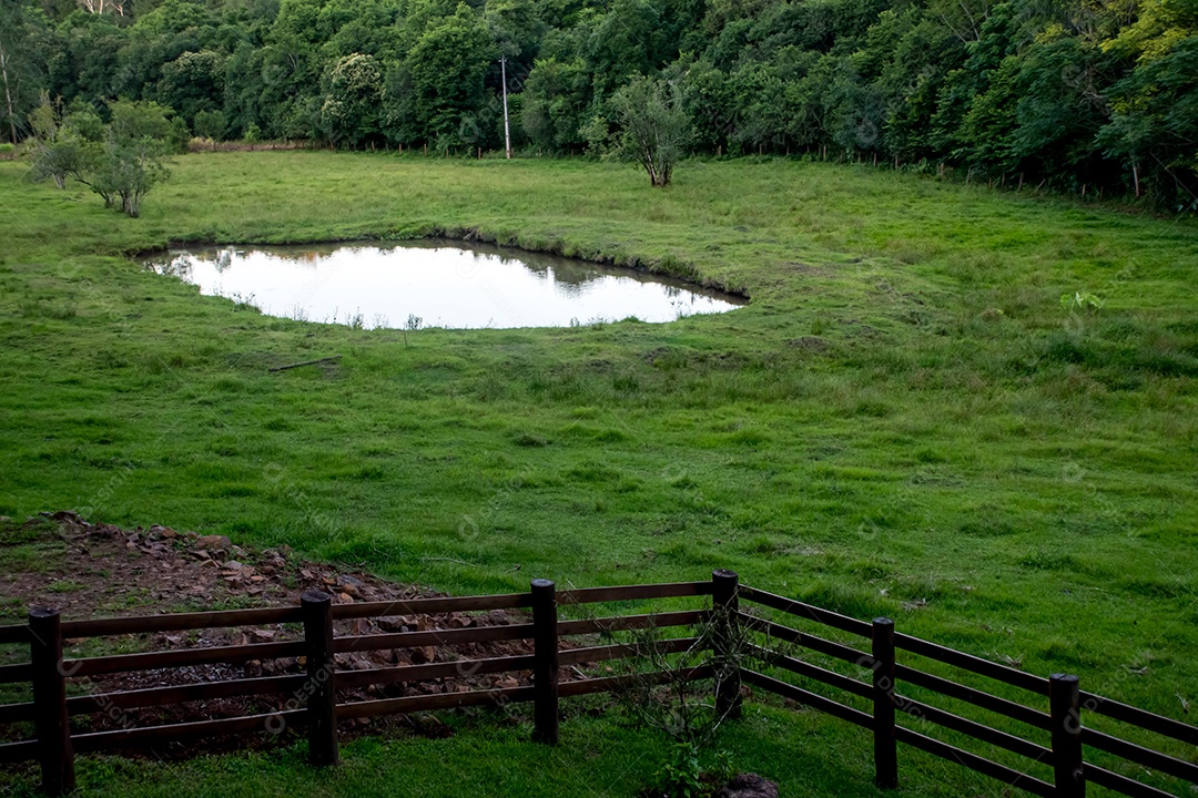 Cerca de madeira gramado e lago campo