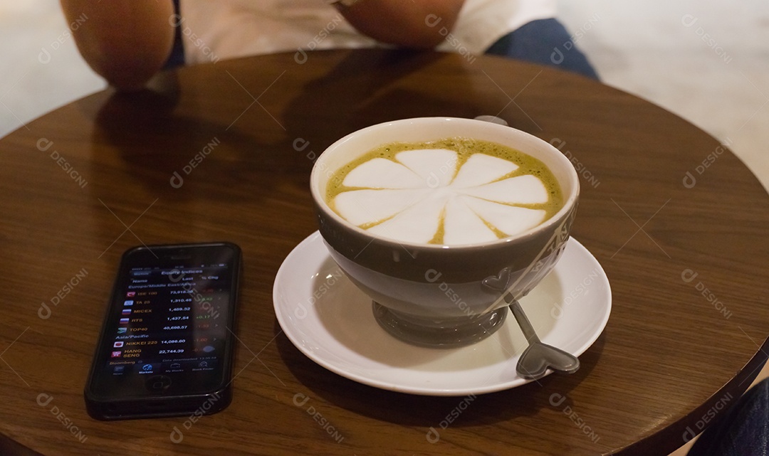 Cappuccino em xícara em prato ao lado de smartphone tecnologia avançada sobre mesa de madeira