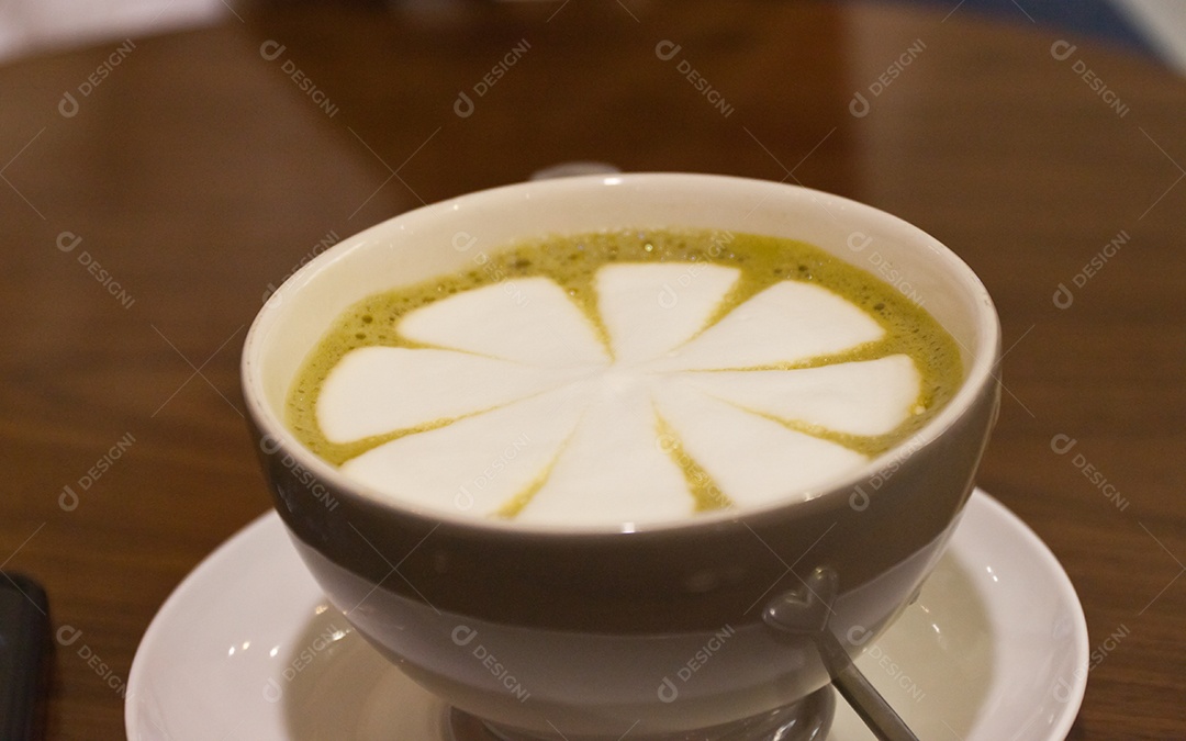 Cappuccino em xícara em prato sobre mesa de madeira