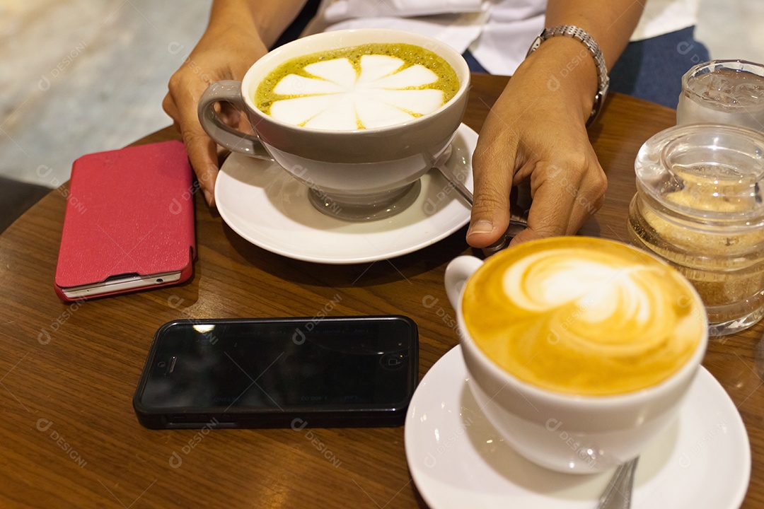 Cappuccino em xícara em prato ao lado de smartphone tecnologia avançada sobre mesa de madeira