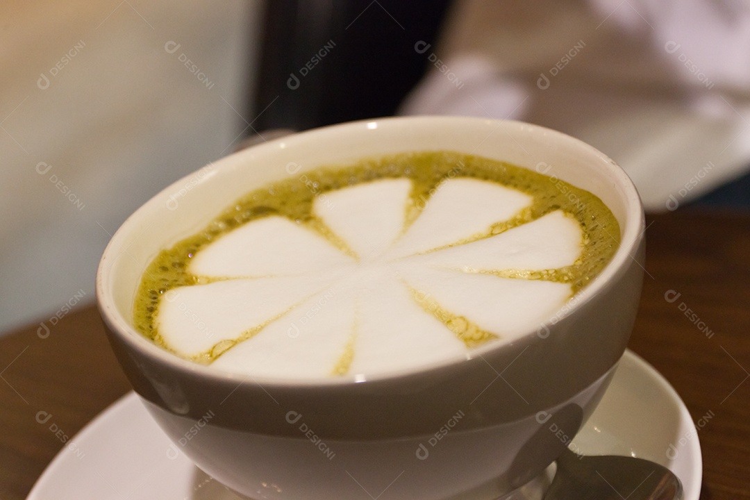 Cappuccino em xícara em prato sobre mesa de madeira