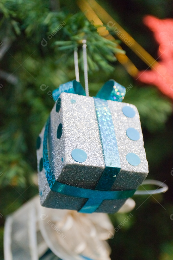 Fundo de natal com caixa de presente prata com laço azul sobre fundo desfocado