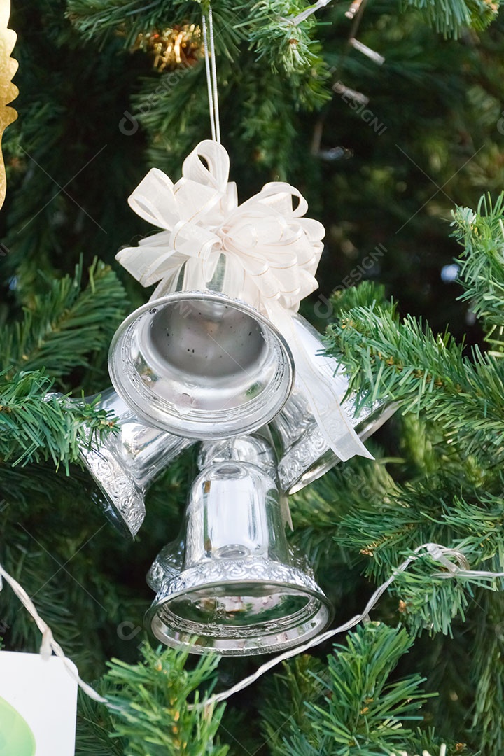 Sino de natal pendurado em árvore de natal natural