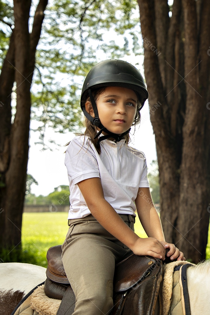 Garota linda montada a cavalo sobre uma fazenda