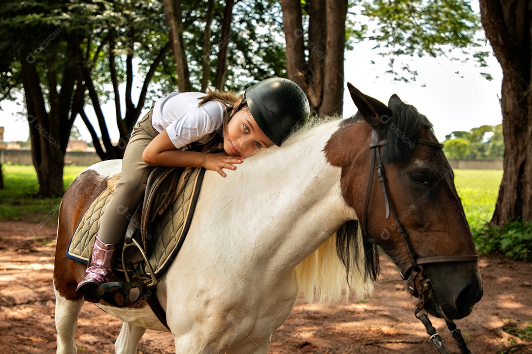 Garota linda montada a cavalo sobre uma fazenda