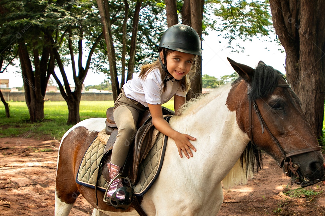 Garota linda montada a cavalo sobre uma fazenda
