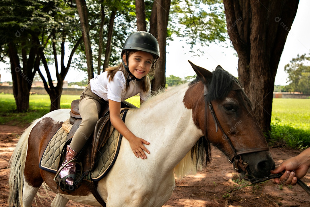 Garota linda montada a cavalo sobre uma fazenda