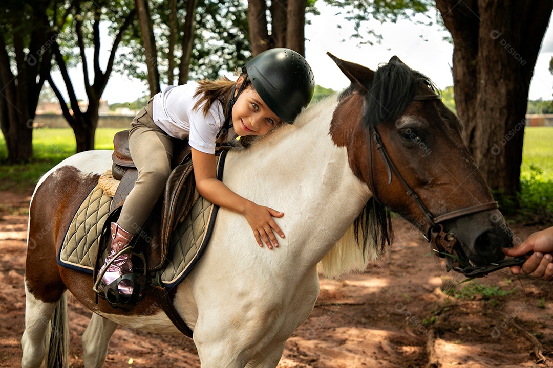 Garota linda montada a cavalo sobre uma fazenda