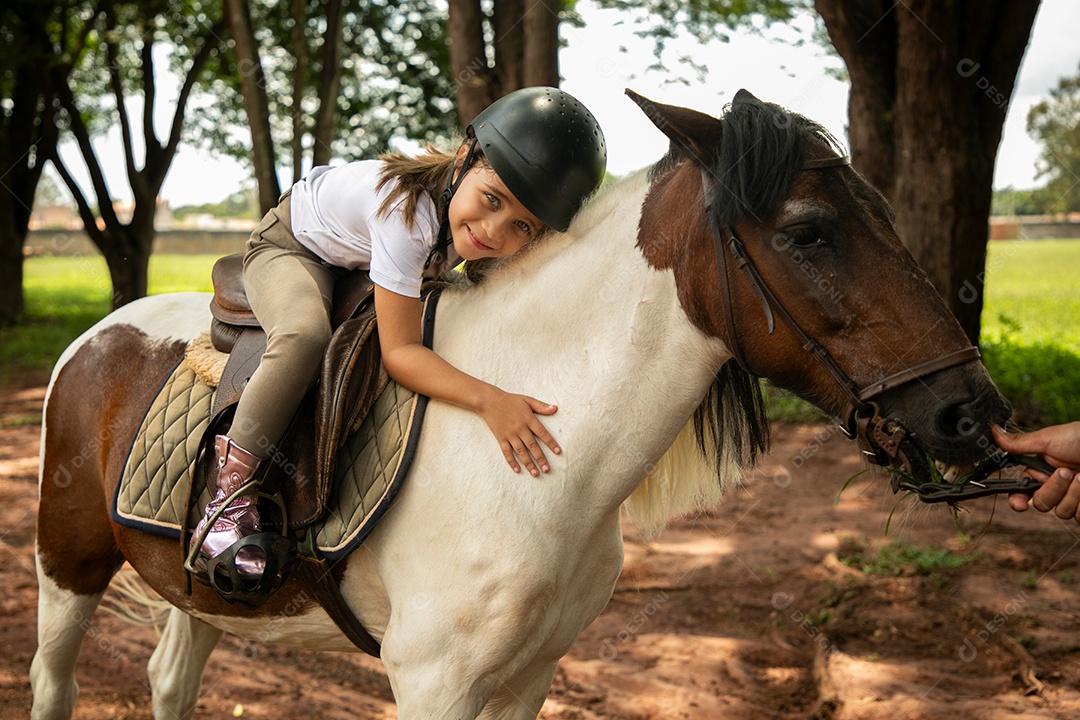 Garota linda montada a cavalo sobre uma fazenda