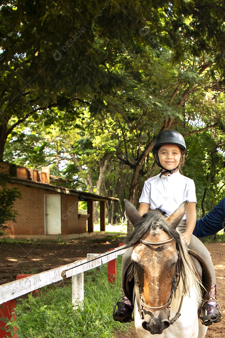 Garota linda montada a cavalo sobre uma fazenda
