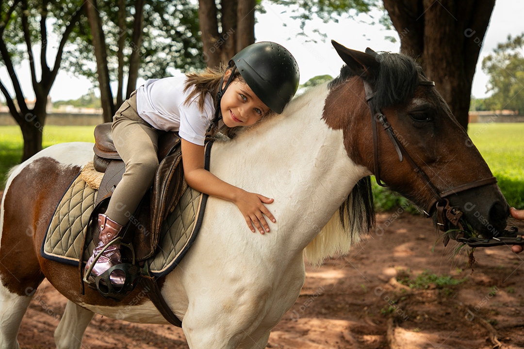Garota linda montada a cavalo sobre uma fazenda