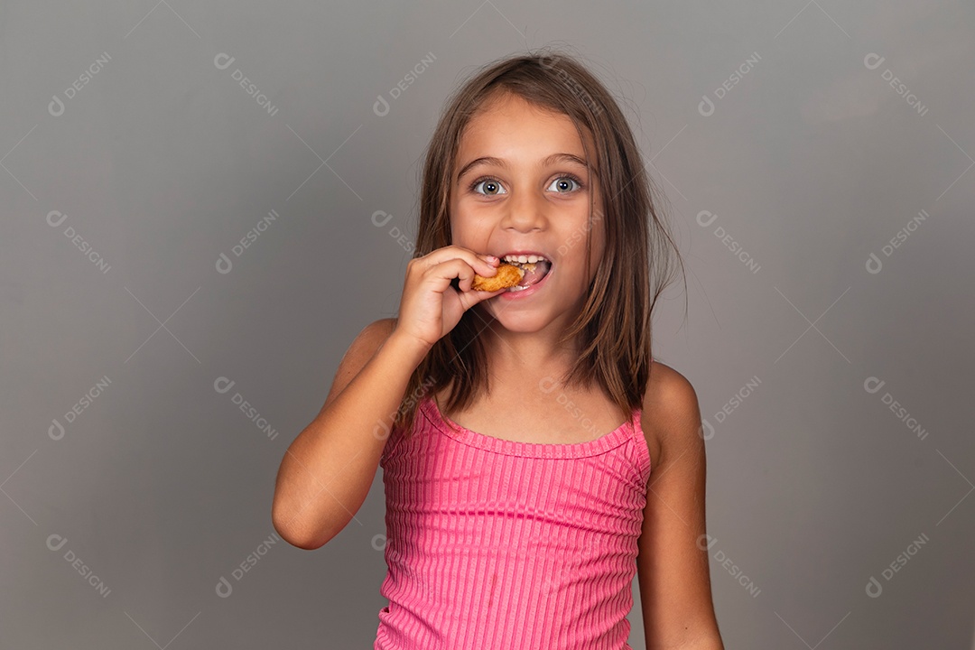 Garota linda comendo biscoito sobre fundo isolado