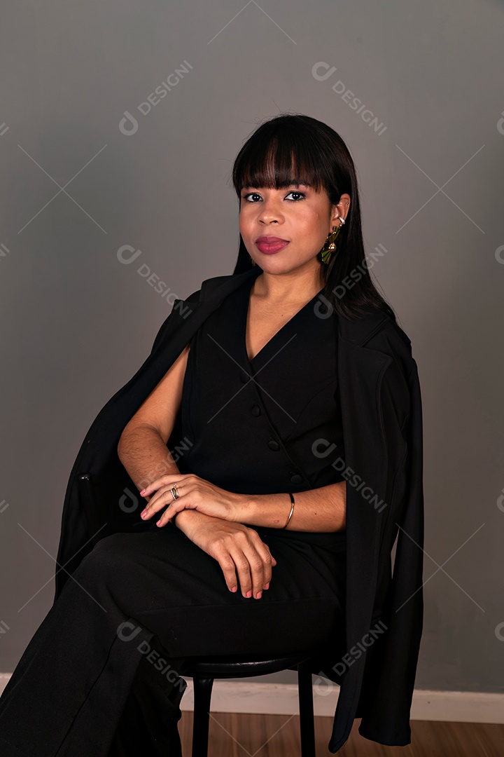 Mulher linda sentada com roupa preta sobre fundo isolado