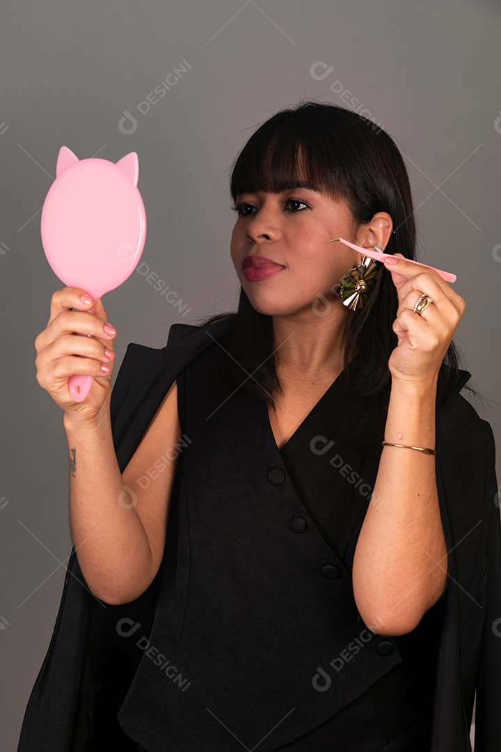 Linda mulher segurando espelho e pinça sobre fundo isolado