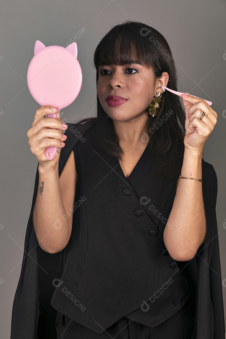 Linda mulher segurando espelho e pinça sobre fundo isolado