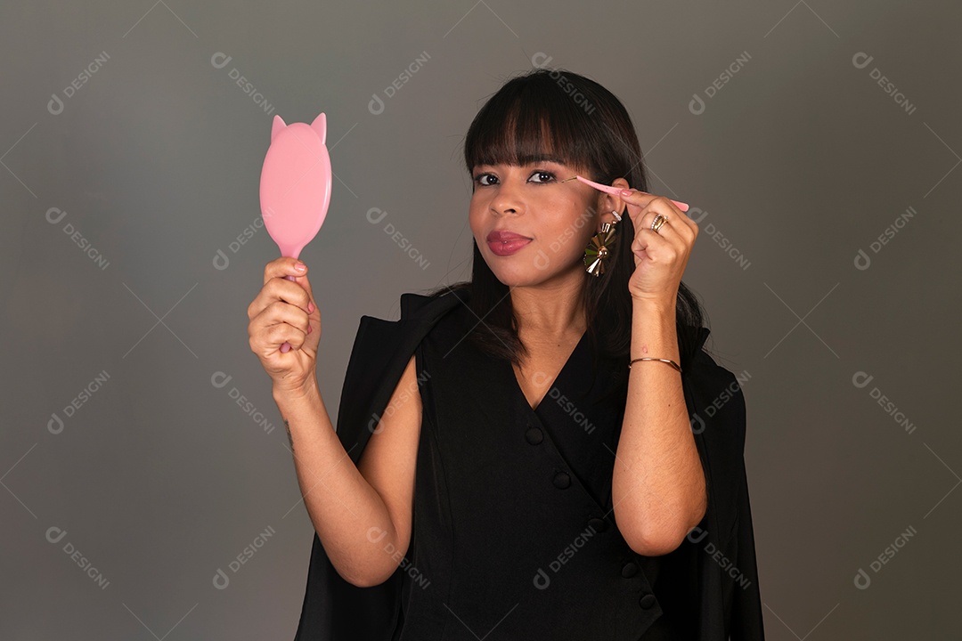 Linda mulher segurando espelho e pinça sobre fundo isolado