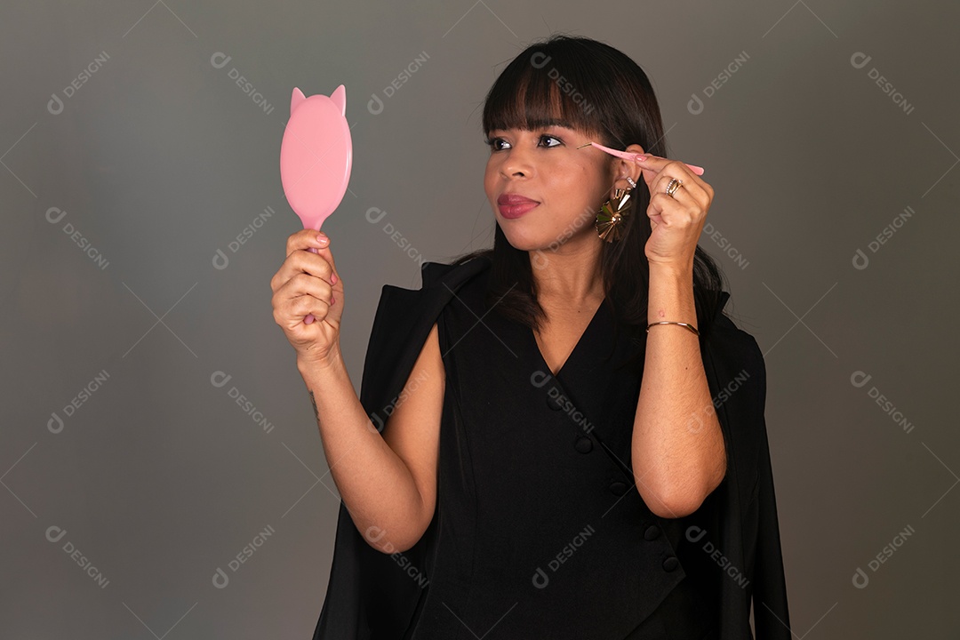 Linda mulher segurando espelho e pinça sobre fundo isolado