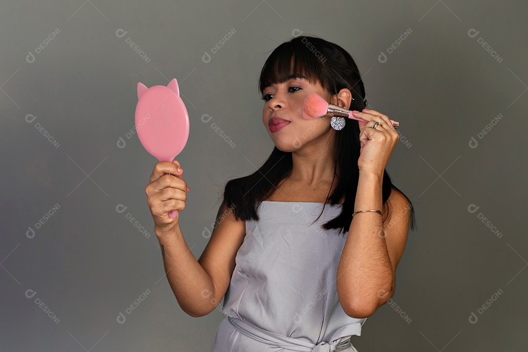 Linda mulher segurando espelho e pincel sobre fundo isolado