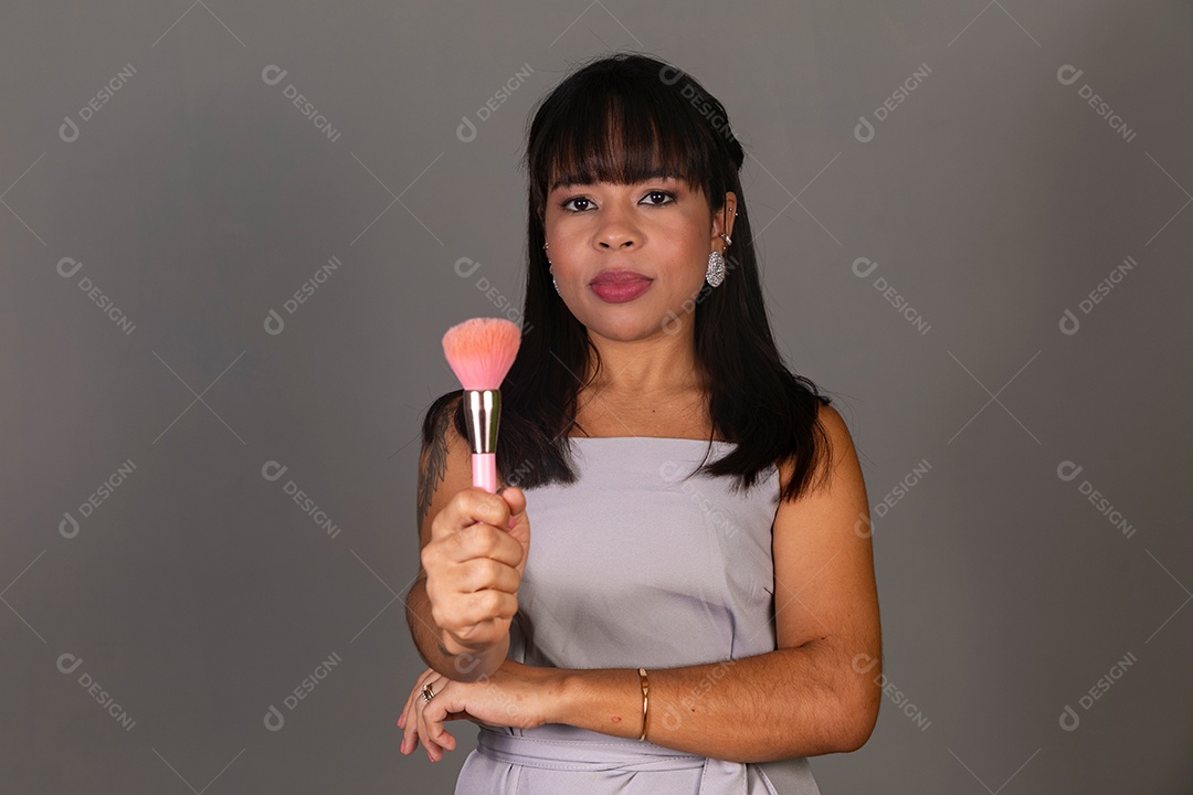 Linda mulher com blusa violeta com pincel sobre fundo isolado