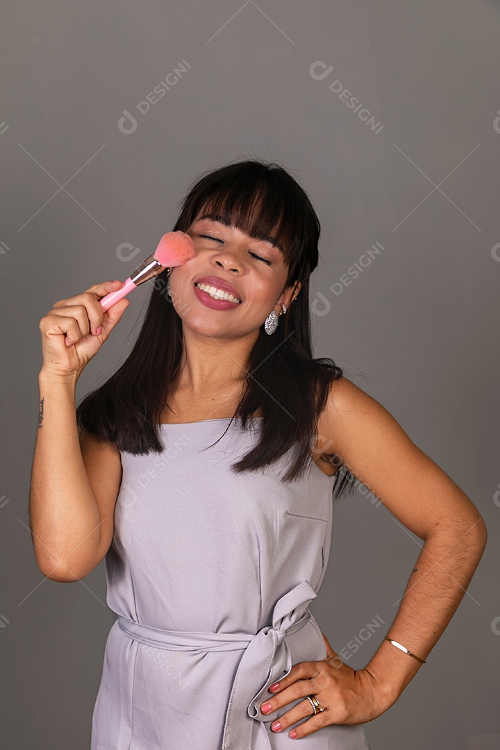 Linda mulher com blusa violeta com pincel sobre fundo isolado