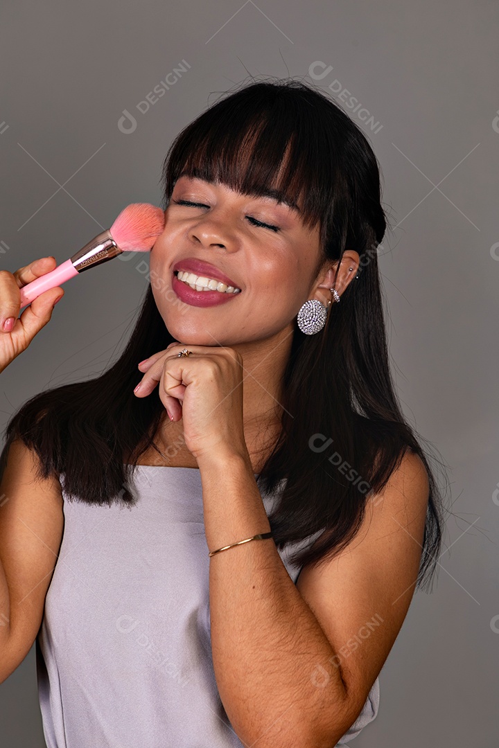 Linda mulher com blusa violeta com pincel sobre fundo isolado