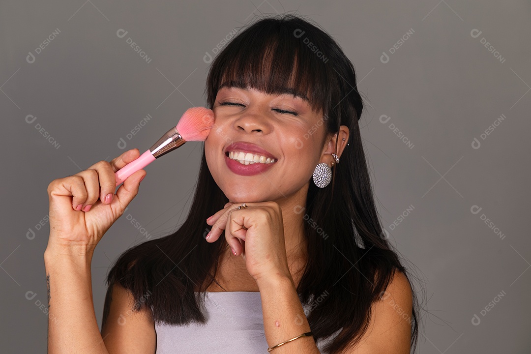 Linda mulher com blusa violeta com pincel sobre fundo isolado