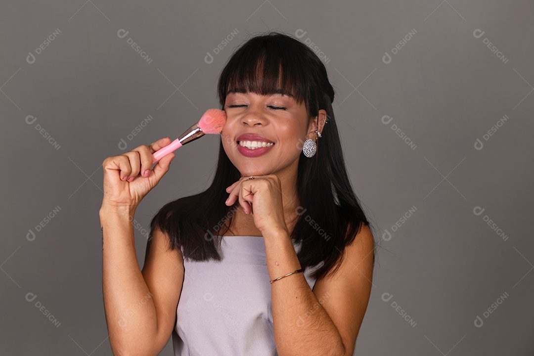 Linda mulher com blusa violeta segurando pincel sobre fundo isolado