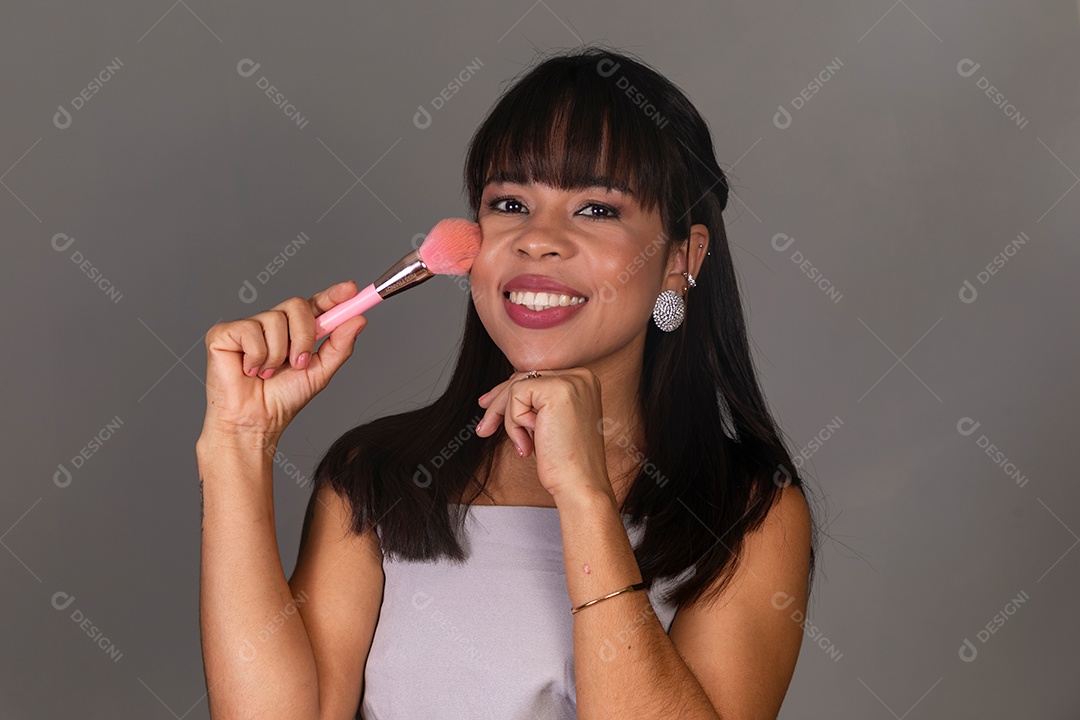 Linda mulher com blusa violeta segurando pincel sobre fundo isolado