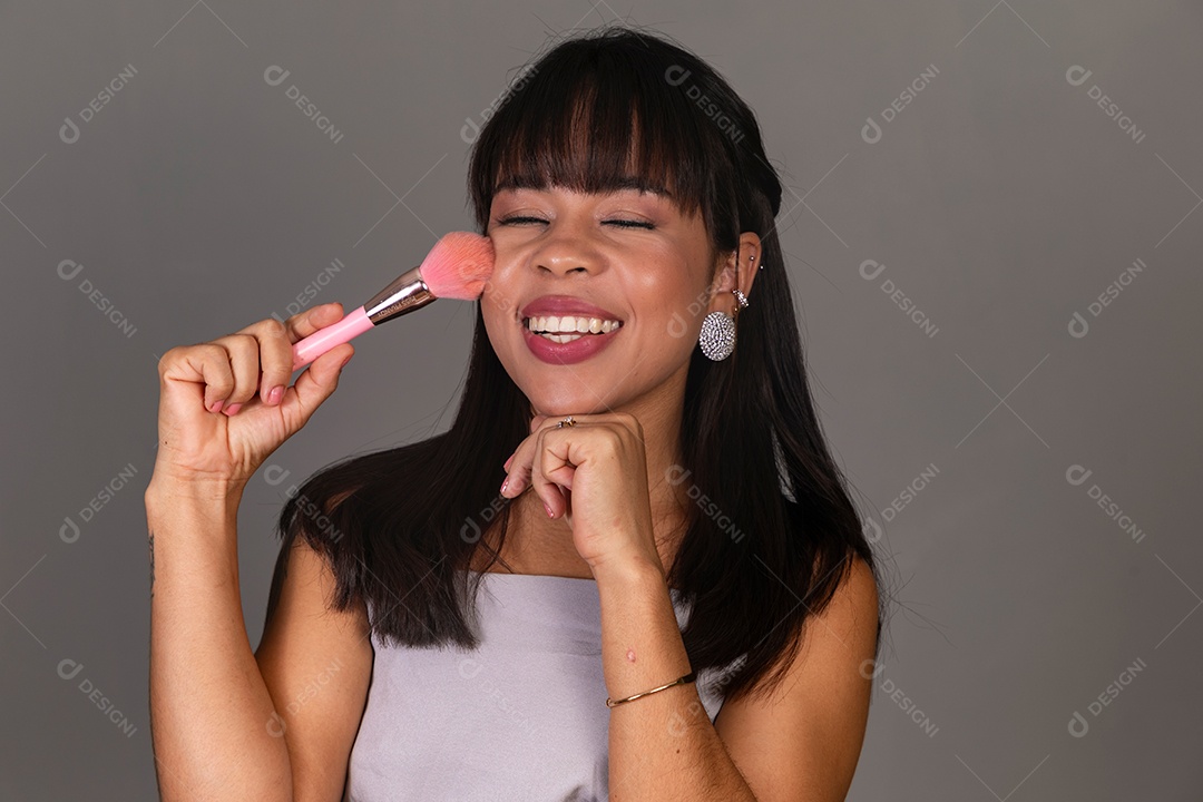 Linda mulher com blusa violeta segurando pincel sobre fundo isolado