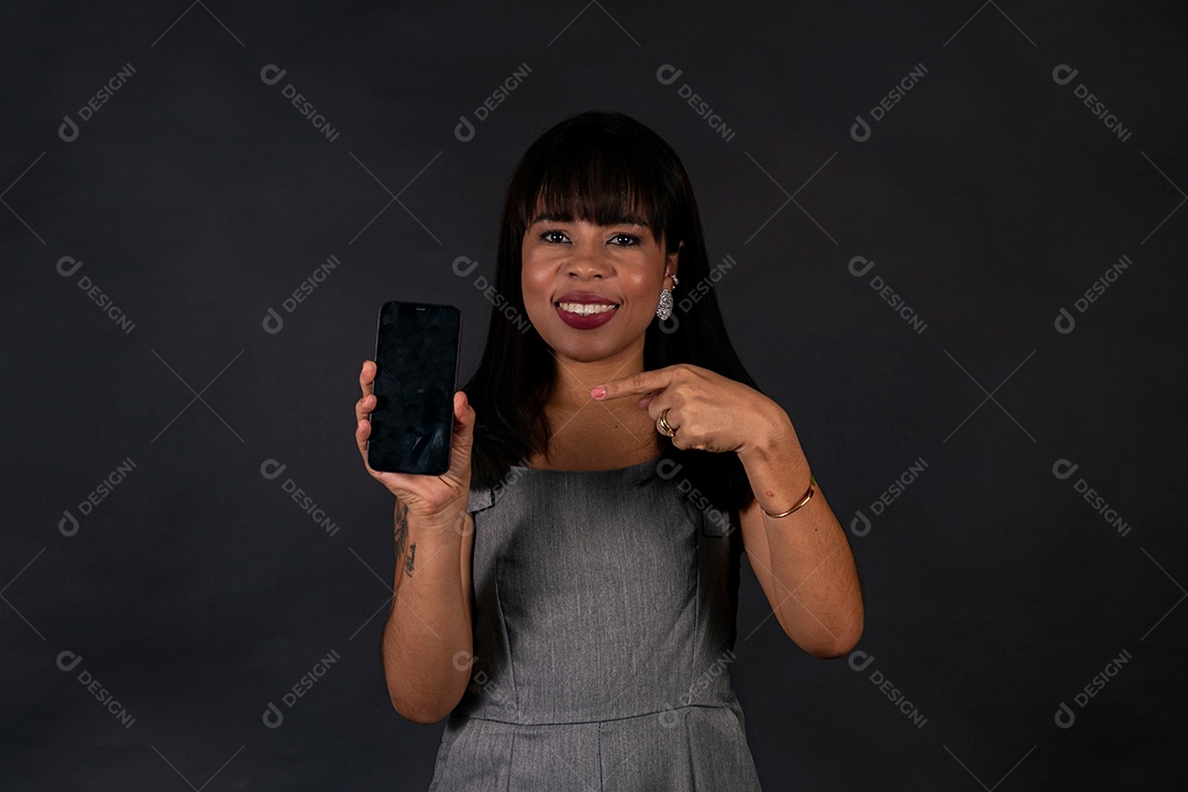 Linda mulher de roupa preta segurando smartphone sobre fundo isolado