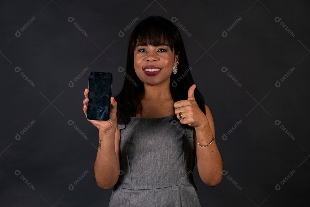 Linda mulher de roupa preta segurando smartphone sobre fundo isolado