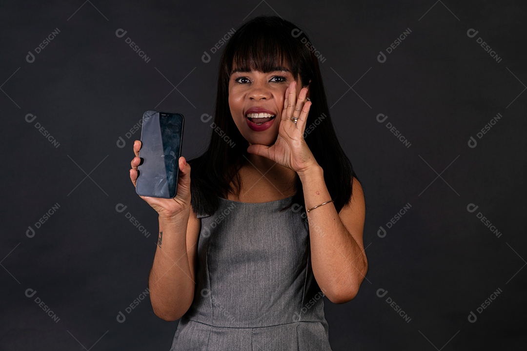 Linda mulher de roupa preta segurando smartphone sobre fundo isolado