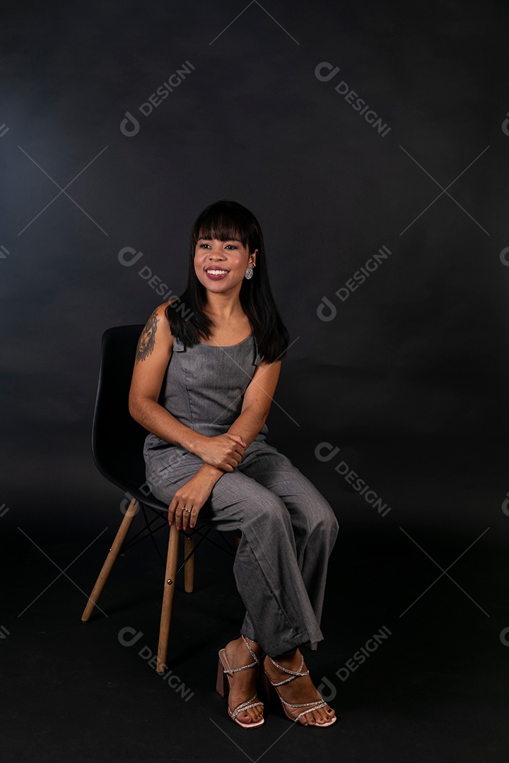 Linda mulher de roupa preta sentada sobre fundo isolado