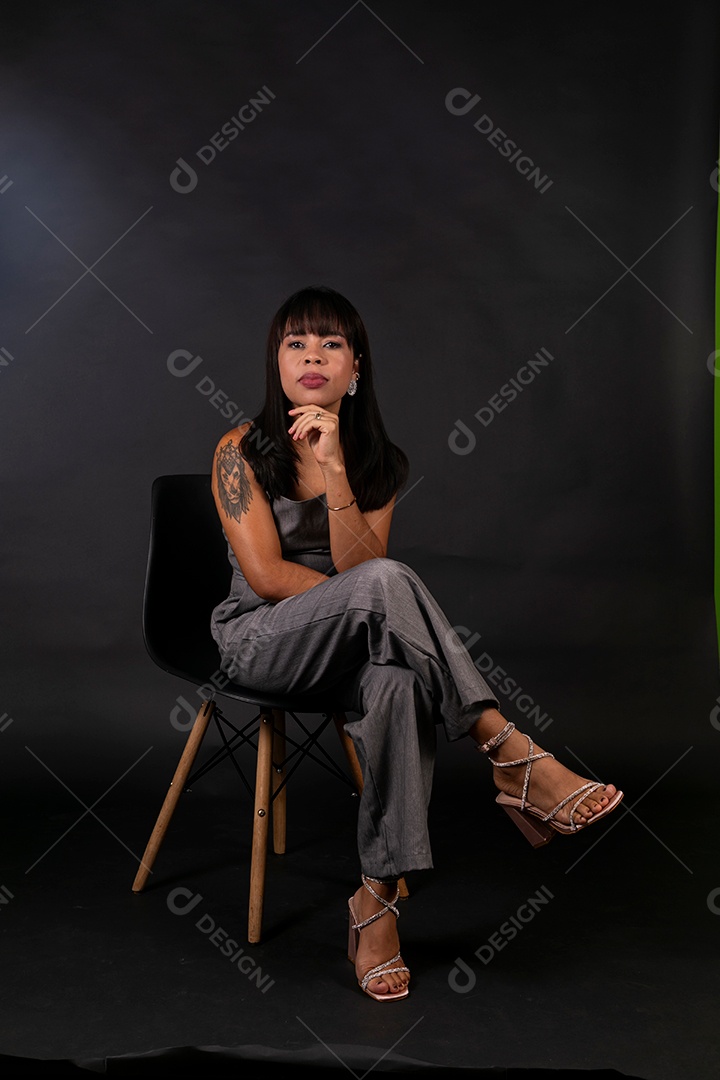 Linda mulher de roupa preta sentada sobre fundo isolado