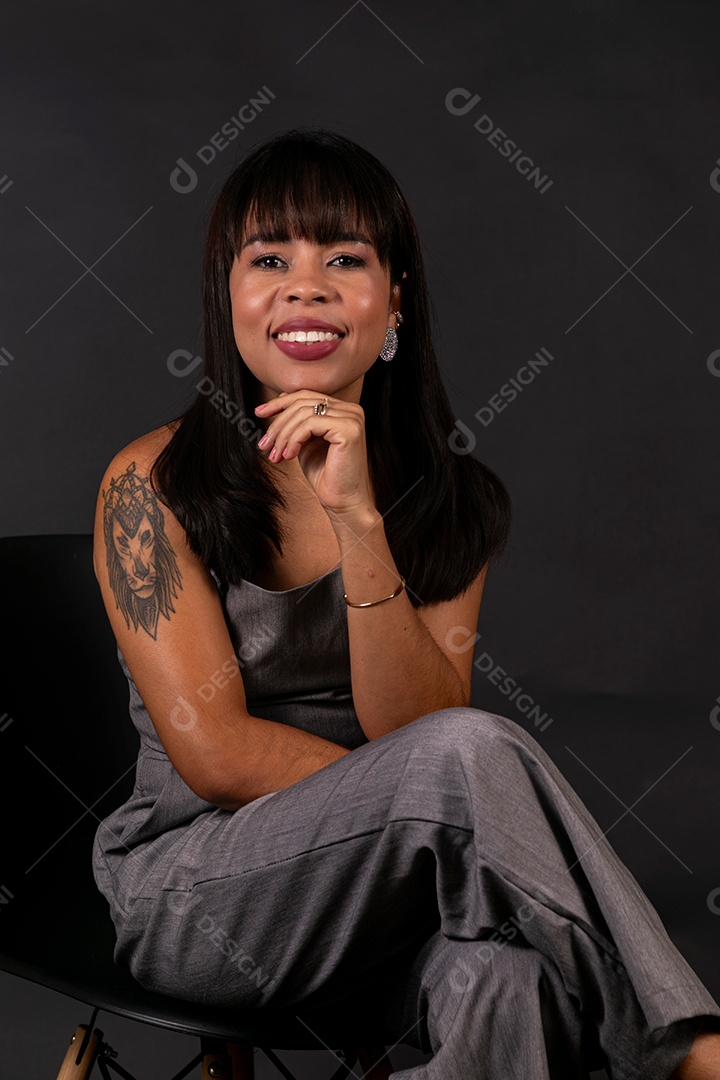 Linda mulher de roupa preta sentada sobre fundo isolado