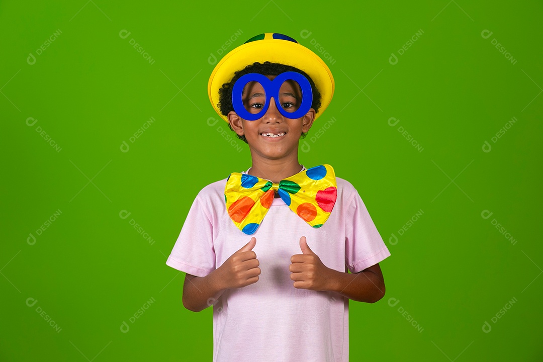 Lindo garoto fantasiado de palhaço sobre fundo verde isolado