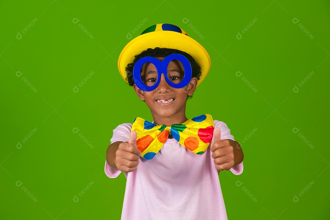Lindo garoto fantasiado de palhaço sobre fundo verde isolado
