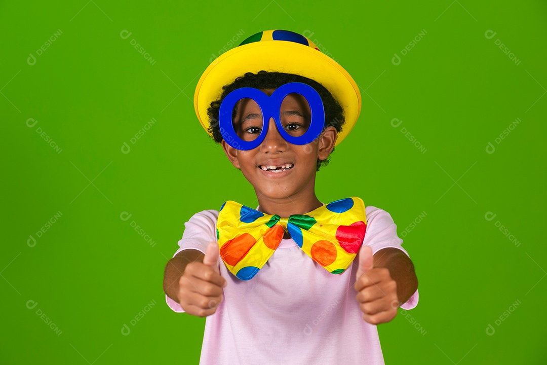 Lindo garoto fantasiado de palhaço sobre fundo verde isolado